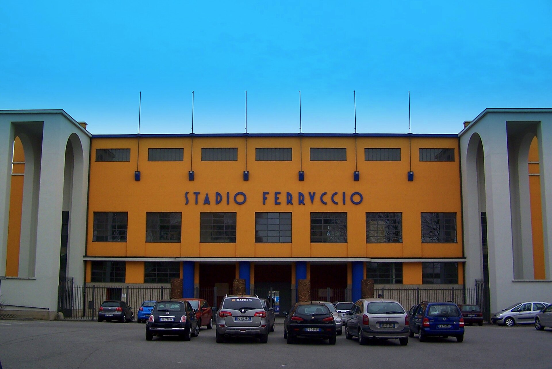 Facciata gialla dello stadio Ferruccio di Seregno con le due torri bianche